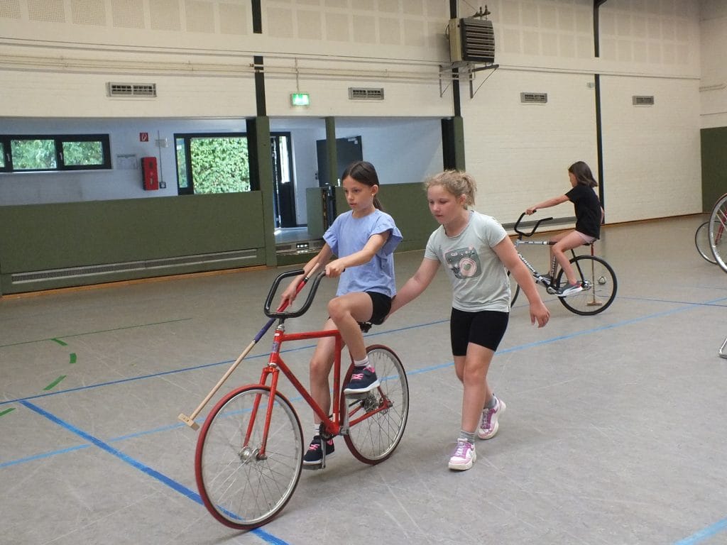 Teamwork auf zwei Rädern: Mit der Hilfe einer Mitschülerin gelingt die erste Fahrt
